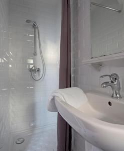 尼斯圣休伯特酒店的白色的浴室设有水槽和淋浴。