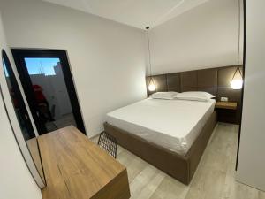 维利波吉White Beach Villa 2 - Luxury的一间卧室配有一张床、一张桌子和一面镜子