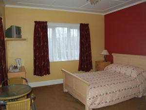 以撒港路端酒店的一间卧室配有一张床、一张桌子和一个窗户。
