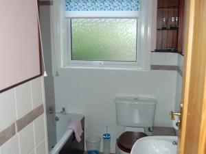 以撒港路端酒店的一间带卫生间和窗户的小浴室