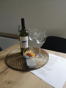 格但斯克Apartamenty 48 Letnica的桌子上放有一瓶葡萄酒和两杯酒