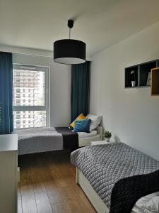 格但斯克Apartamenty 48 Letnica的一间卧室设有两张床、一张沙发和一个窗口