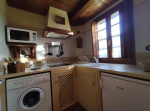 NavecesAsturias Apartamentos Rurales Naveces的厨房配有洗衣机和微波炉。