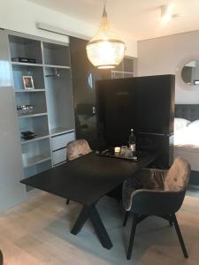 斯图加特Sky Aparthotel的一张黑桌子和椅子,位于一个配有床的房间
