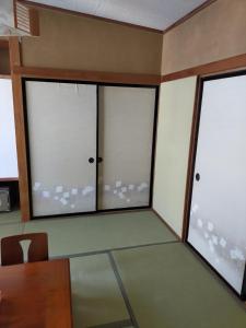 秩父市Suijin Hotel - Vacation STAY 38314v的客房设有3扇窗户和桌椅。