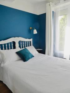PuimoissonLa Lavandière的蓝色的卧室设有白色的床和蓝色的墙壁