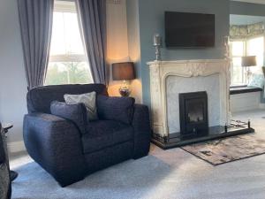 卡斯莱兰Tailors Lodge, Luxurious peaceful Apartment- Castleisland, Kerry的客厅配有椅子和壁炉