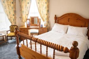 布莱奈费斯蒂尼奥格isallt guesthouse的一间卧室配有一张木床、一张书桌和一个窗户。