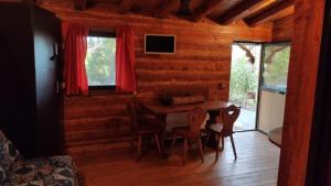 佩达拉Etna Rural Cottage with Jacuzzi的小木屋内带桌椅的用餐室