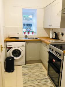 邓巴顿Whiteley's Cottages的厨房配有水槽和洗衣机