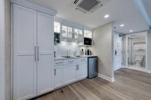 阿瓦隆ICONA Avalon的厨房配有白色橱柜和卫生间。