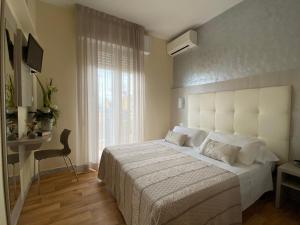 里米尼珍宝酒店的卧室设有一张白色大床和一扇窗户。