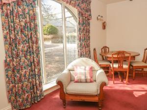 伍勒Cherryburn Cottage的客厅配有椅子和窗户
