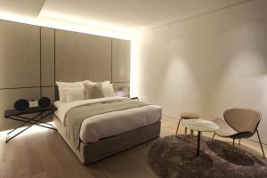 华城市JS经典酒店的一间卧室配有一张大床和一把椅子