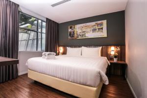 吉隆坡Days Hotel & Suites by Wyndham Fraser Business Park KL的一间设有大床和窗户的酒店客房