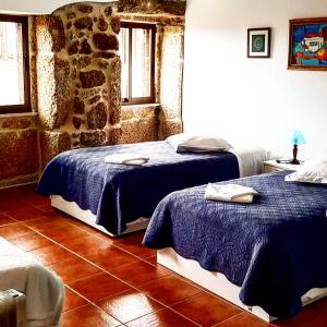 贝尔蒙特Casa Dom Yahya的一间卧室设有两张床和石墙