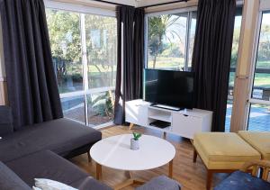 蚬壳港NRMA Shellharbour Beachside Holiday Park的带沙发和电视的客厅