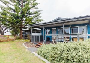 蚬壳港NRMA Shellharbour Beachside Holiday Park的前面有棕榈树的蓝色房子