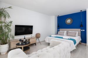伊利索斯Bamboo Suites Hotel的一间卧室设有两张床和蓝色的墙壁