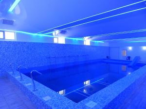 克利默内什蒂Hotel Traian Caciulata的浴室设有蓝色灯光游泳池