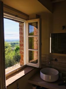 蒙特普齐亚诺La Falconara的一间带水槽的浴室和一个美景窗户