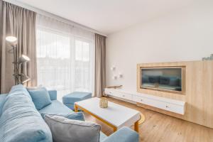 米兹多洛杰Bel Mare Resort Apartment with Parking by Renters的客厅配有蓝色的沙发和电视
