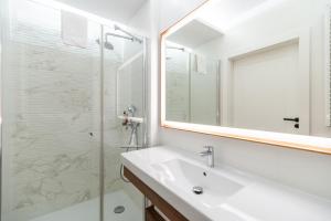 米兹多洛杰Bel Mare Resort Apartment with Parking by Renters的一间带水槽和玻璃淋浴的浴室