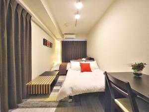 Chikusachōケイアイコンホテルズ ふくしあ503的酒店客房设有两张床和一张桌子。