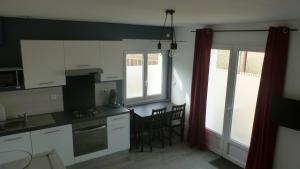 沙斯讷伊迪普瓦图Logements Le232 fr的厨房配有白色橱柜和桌椅