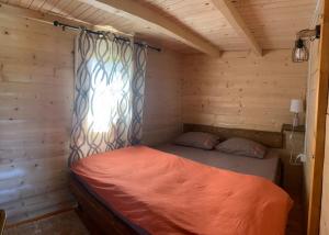 采蒂涅Cabin House Dubovik的木制客房的一张床位,设有窗户