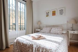 塞维利亚Geranium House的白色卧室,配有带毛巾的床