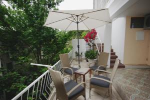兹沃格谢Apartmani Slaviček的庭院配有桌椅和遮阳伞。