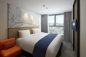 首尔首尔弘大智选假日酒店的酒店客房带一张大床和一把椅子