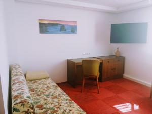 NieskyFerienhaus Niesky的一间卧室配有一张床、一张书桌和一台电视