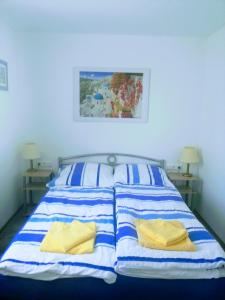NieskyFerienhaus Niesky的一张带蓝色和白色条纹床单和黄色枕头的床