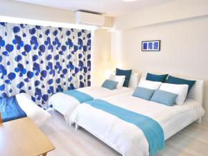 Chikusachōケイアイコンホテルズ ふくしあ801的蓝色和白色的客房内的两张床