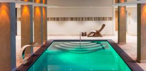维皮泰诺维斯奈霍夫酒店的一个带椅子的房间中间的游泳池