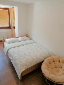 特拉夫尼克Kod Lipe - Travnik的一间卧室配有一张床和一把椅子