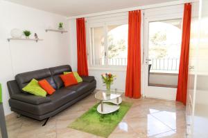 萨永Un moment de détente inoubliable Saillon-les-Bain的客厅配有黑色皮革沙发和橙色窗帘
