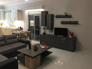 卡拉马孔Liri's Apartments的客厅配有沙发和桌子