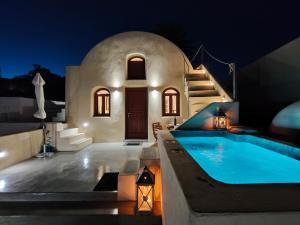 安坡里奥圣托里尼Dreamer's secret villa的夜间带游泳池的别墅