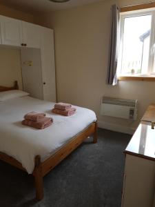 NavershawLindisfarne Self Catering的一间卧室配有一张床,上面有两条毛巾