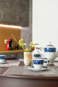 古卡斯特隆Achilles Maisonette的一张桌子上放着蓝色和白色的杯子和鲜花
