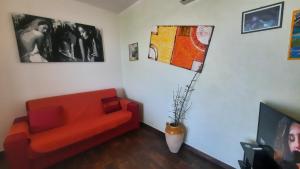卡萨马塞拉Fata Morgana的客厅配有红色的沙发和一些图片