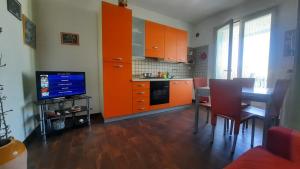 卡萨马塞拉Fata Morgana的厨房配有橙色橱柜、桌子和电视。