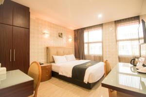吉隆坡Suwara Hotel Kepong KL的配有一张床和一张书桌的酒店客房