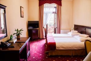 威利兹卡图洛卡酒店和Spa的酒店客房配有一张床、一张书桌和一台电视。