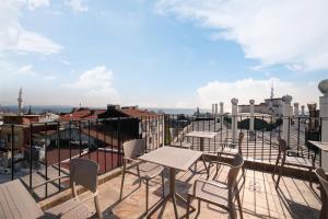 伊斯坦布尔SEVEN ROSES APART HOTEL的屋顶上带桌椅的天井