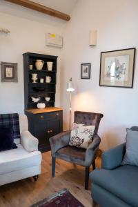 奥斯威斯Courtyard Cottage的客厅配有沙发、椅子和桌子