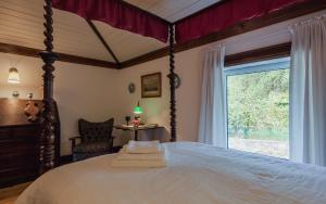 吉马良斯1720 Quinta da Cancela - Winery & Farmhouse的一间卧室设有一张大床和一个窗户。